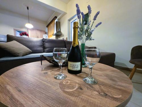 a bottle of champagne and two wine glasses on a table at Leonidas Private Apartment in Sparta in Sparti