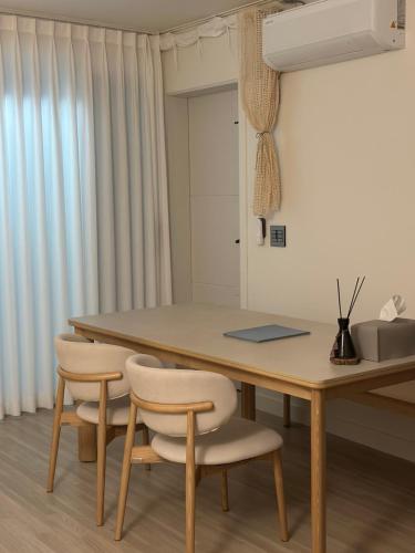 a dining room table with two chairs and a table at A peaceful rest stop on your journey in Busan