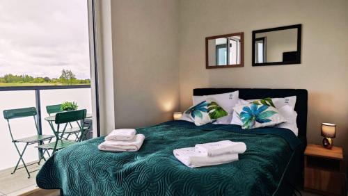 a bedroom with a bed with towels on it at Apartament Szczęśliwy - 14 in Ustronie Morskie