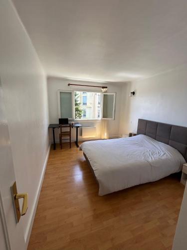une chambre avec un lit blanc et un bureau dans l'établissement Cosy appartement en plein centre-ville dans un halo de verdure avec vue mer, à Nice