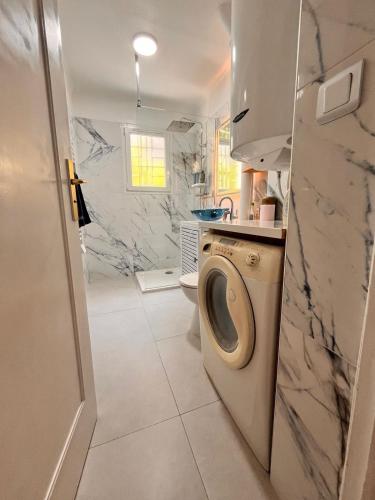 - une buanderie avec un lave-linge et un sèche-linge dans la salle de bains dans l'établissement Cosy appartement en plein centre-ville dans un halo de verdure avec vue mer, à Nice