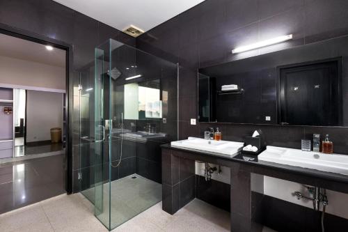 a bathroom with two sinks and a glass shower at Villa Ocean's Height in Kuta