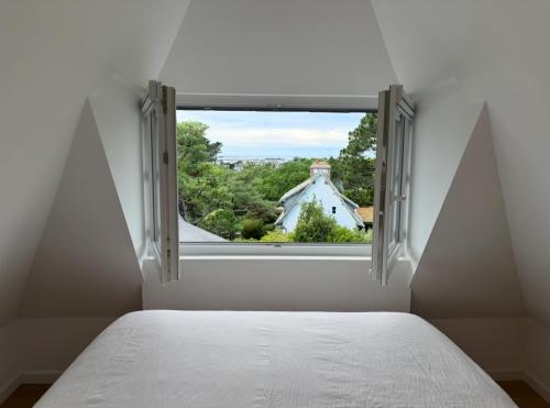 - une chambre avec une fenêtre donnant sur une maison dans l'établissement La Pagode, à Trégastel
