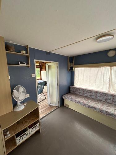 a small room with a bed and a window at Mobile Home Bleu in Fleurac