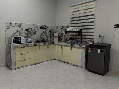 a kitchen with a counter and a refrigerator at Homestay Aulia, Dungun, Terengganu in Dungun