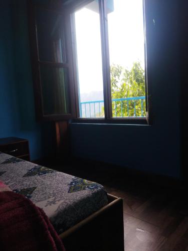 a blue room with a bed and a window at Sheetal Restaurant in Mussoorie
