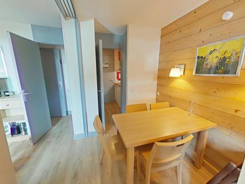 une salle à manger avec une table et des chaises en bois dans l'établissement Appartement cosy à La Plagne avec balcon ensoleillé et parking couvert - FR-1-351-250, à La Plagne Tarentaise