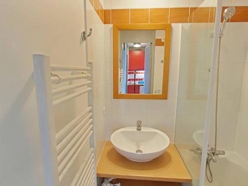 une salle de bain avec un lavabo blanc et un miroir dans l'établissement Appartement cosy à La Plagne avec balcon ensoleillé et parking couvert - FR-1-351-250, à La Plagne Tarentaise