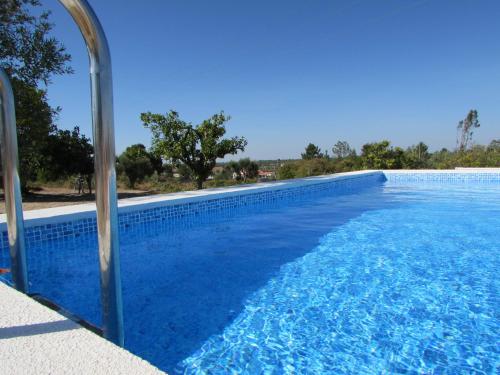 a blue swimming pool with a clear blue sky at Quinta Rural em Coruche com piscina privativa in Coruche