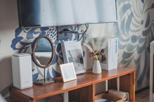 a wooden table with a mirror and books on it at 北海道伊達の海辺ヴィラ 最大7名一棟貸切 ファミリー向け 北斎アート in Date