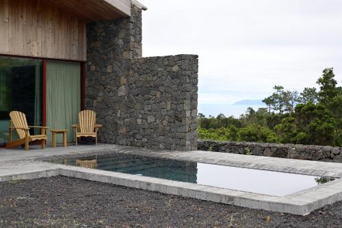 a patio with a table and chairs next to a house at Pico Vineyards - by Unlock Hotels in Bandeiras