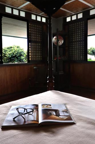 a book with a pair of glasses sitting on a table at Estancia Primavera in Angeles City in Mining