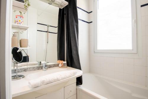 a bathroom with a sink and a tub and a window at Large Quiet House, in the city center in Lille