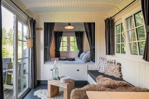 a small room with a bed and a table at Nature lovers Amsterdam Zaandam in Wijdewormer