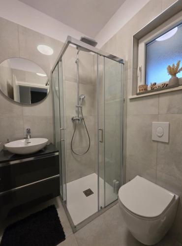 a bathroom with a shower and a toilet and a sink at Apartman Peršić 2 in Sveta Marina