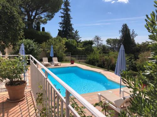 - une piscine sur une terrasse avec des chaises et des parasols dans l'établissement LA MAISON BLEUE Piscine Grand Jardin - 4 CHh- 3 Sdb, à La Celle-sous-Gouzon