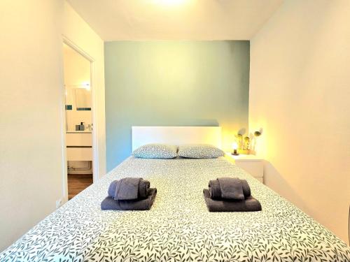 une chambre avec un lit avec deux serviettes dessus dans l'établissement À Pas de Tout, à Vannes