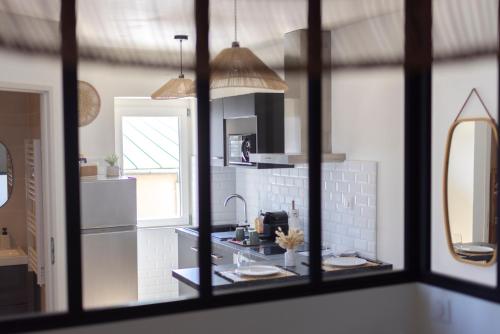 a kitchen with a sink and a mirror at Lumineux Cocon - Centre Historique - 5min Gare in Brive-la-Gaillarde