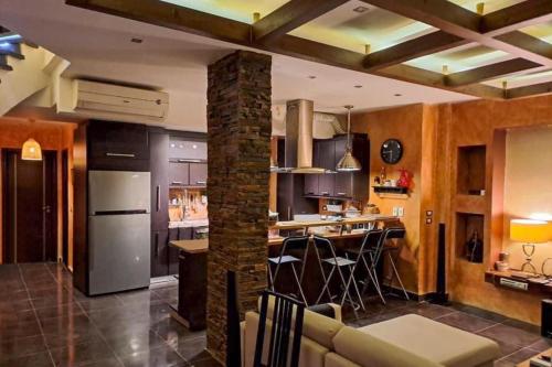 eine Küche und ein Wohnzimmer mit einem Kühlschrank und einer Theke in der Unterkunft Family-Friendly Beach Getaway with Jacuzzi-Garden-Resort and Mountain Views in Sharm El Sheikh