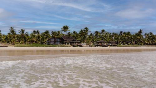a view of a beach with houses and palm trees at Indaiá Eco Village in Ilhéus