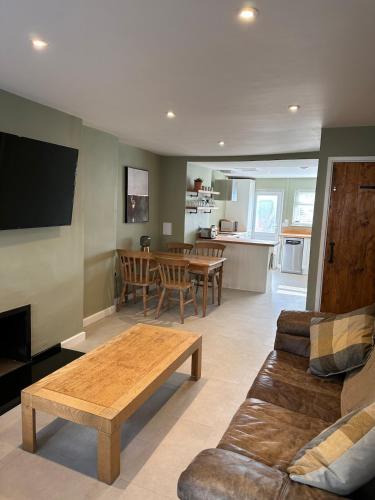a living room with a couch and a table at Bear cottage in Brecon