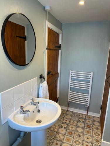 a bathroom with a sink and a mirror at Bear cottage in Brecon