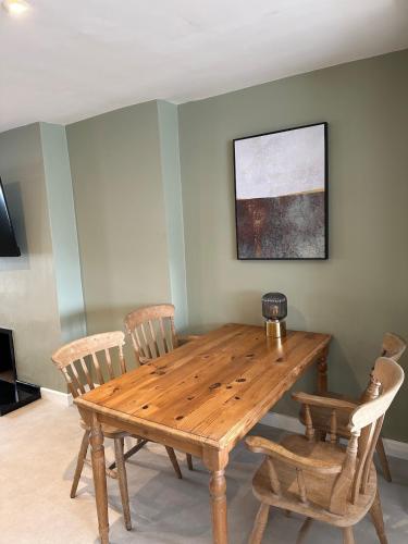 a wooden table and chairs in a room at Bear cottage in Brecon