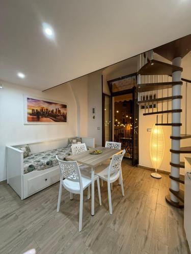 a dining room with a table and chairs and a bed at La Maison di Annamaria in Bari