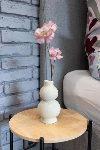 a white vase with pink flowers on a table at Harzerfüllt in Hahnenklee in Hahnenklee-Bockswiese