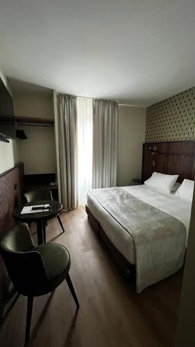 a bedroom with a bed and a table and a chair at Zanhotel Tre Vecchi in Bologna