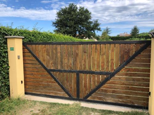 une clôture en bois avec un portail en bois dans l'établissement Au doux paillis soleil couchant, à La Celle-sous-Gouzon