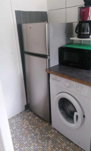 une cuisine avec un réfrigérateur et une machine à laver dans l'établissement Les 2 Jumeaux, à Hendaye