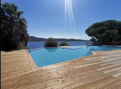 - une piscine à côté d'un corps d'eau dans l'établissement Luxueux T4 de 100m2 avec roof top, piscine et plage, à Pianottoli-Caldarello