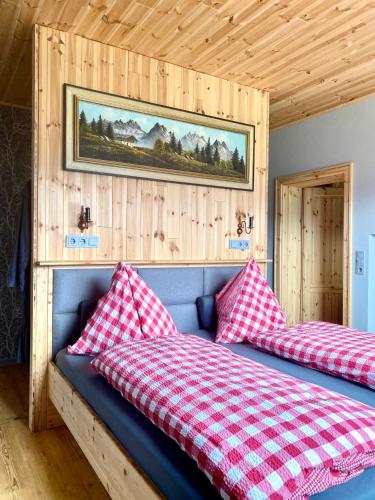 a bedroom with two beds with red and white pillows at s`gmiatli in Iselsberg