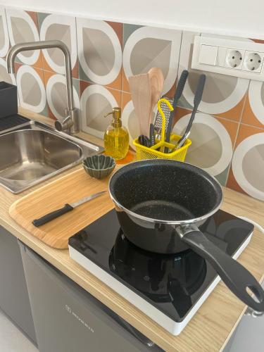 a pan sitting on top of a stove in a kitchen at Blue Bergamote - Pop Culture Suite in Ermoupoli