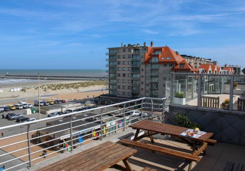 a balcony with benches and a view of the beach at Hotel Uilenspiegel in Nieuwpoort