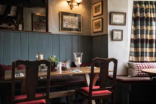 a dining room with a table and two chairs at The Howard Arms in Ilmington