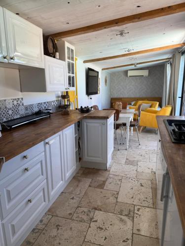 une cuisine avec des placards blancs et une salle à manger dans l'établissement Charmant studio pour 2 personnes avec piscine Idéal pour une escapade relaxante, à Uchaux