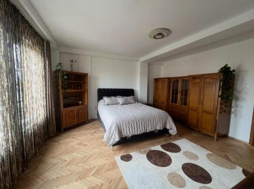 a bedroom with a bed and wooden cabinets and a rug at Gjakova Apartment in Gjakove