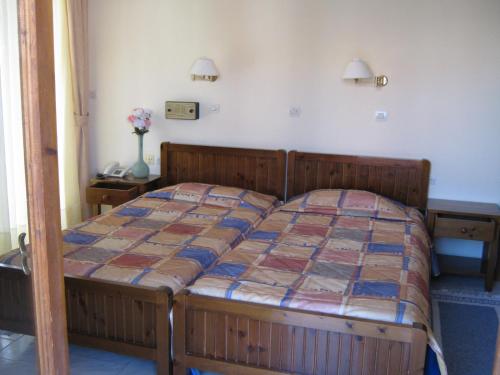 a bedroom with a wooden bed with a quilt on it at Odyssey Hotel Apartments in Karpathos