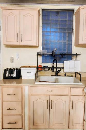 a kitchen counter with a sink and a window at Nica Mango Tree Casa in Managua