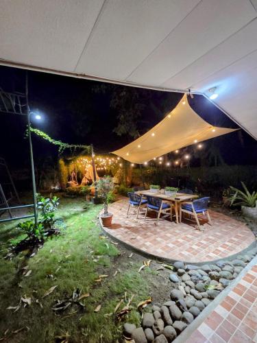 a patio with a table and chairs under an umbrella at Nica Mango Tree Casa in Managua