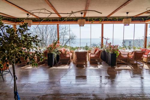 a dining room with tables and chairs and windows at Aqua View SPA Boutique Hotel in Golden Sands
