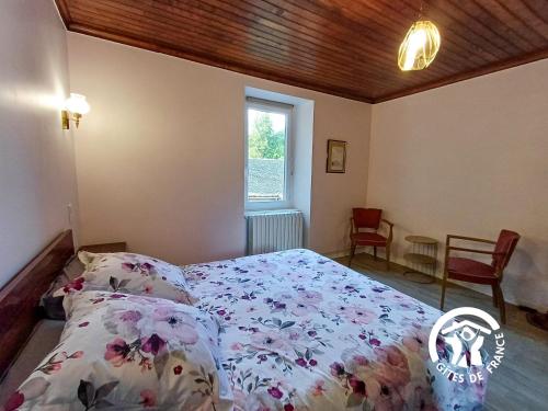 - une chambre avec un lit doté d'un couvre-lit floral et d'une fenêtre dans l'établissement test, à Rodez