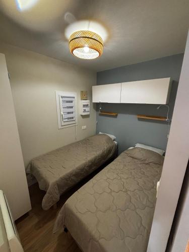 Cette chambre comprend 2 lits et un plafond. dans l'établissement Superbe Appartement T2 climatisé, à Gruissan