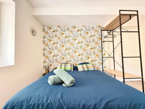 - un lit avec une couette bleue et un oreiller dans l'établissement SV - Studio de l'Opéra VieuxPort, à Marseille