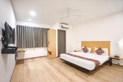 a hotel room with a bed and a television at Via Royale 49 in Noida
