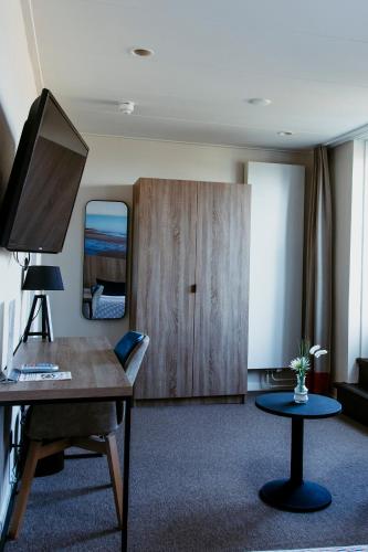 a living room with a desk and a mirror at Hotel Victoria in Bergen aan Zee