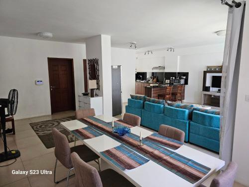 a living room with a table and a blue couch at Mahina Sunset Heights in Flic-en-Flac