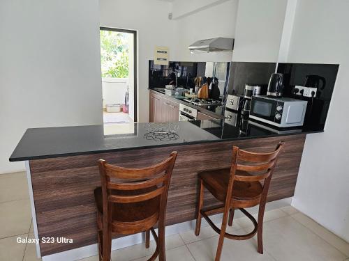 a kitchen with two chairs and a counter top at Mahina Sunset Heights in Flic-en-Flac